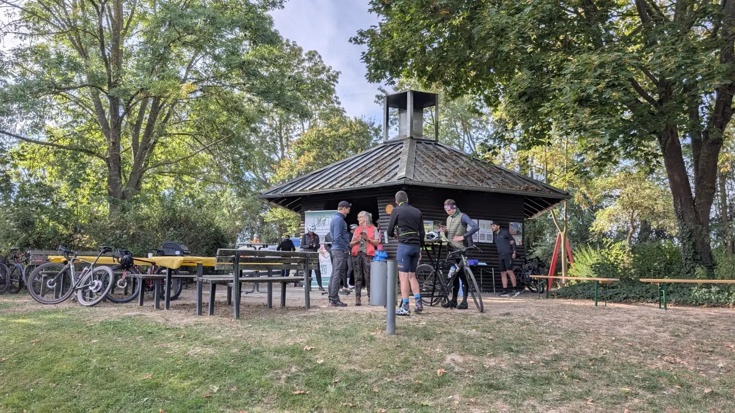 Weitwinkelansicht der Grillhütte mit Teilnehmern und Fahrrädern