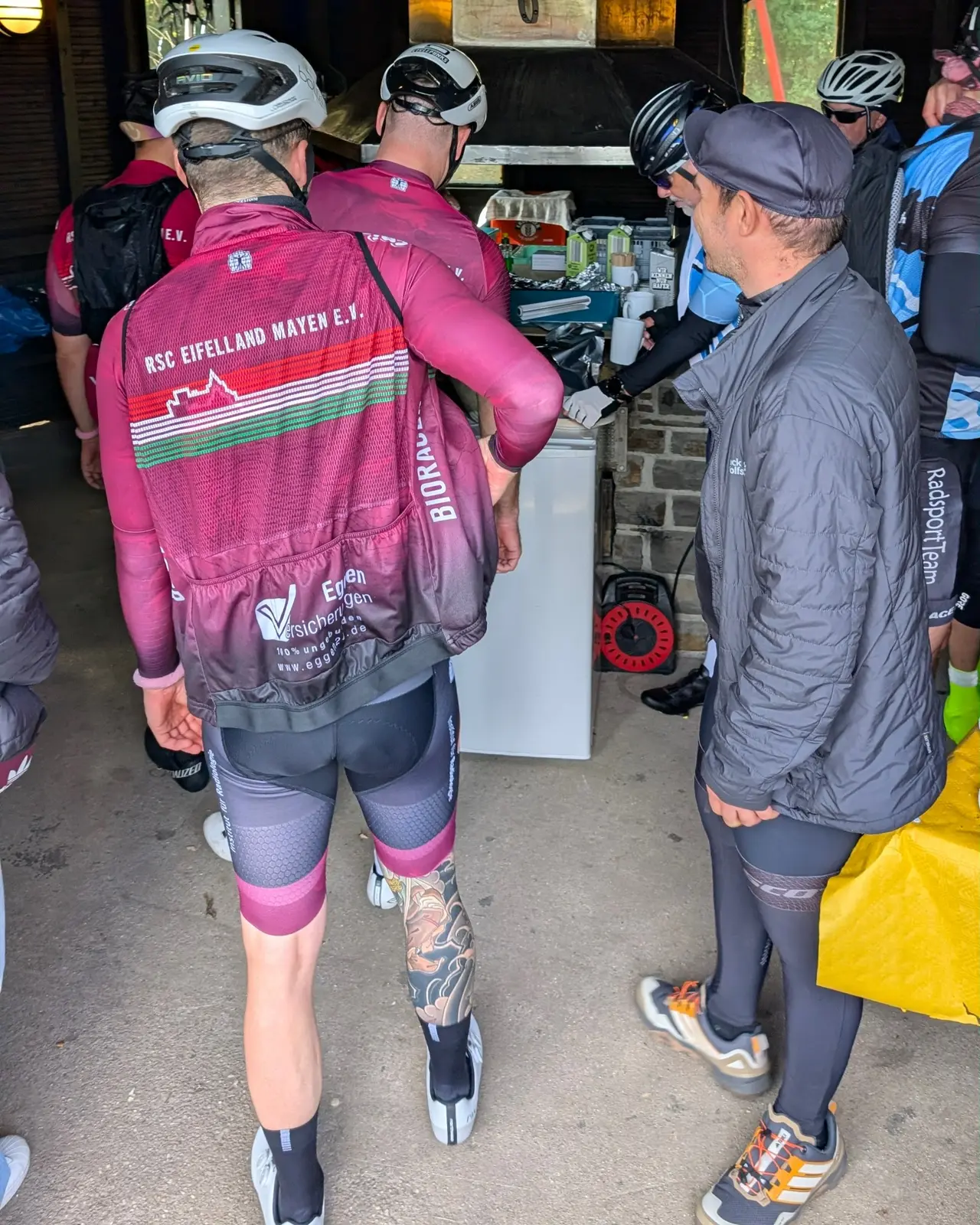 Rennradfahrer auf der Strecke vor einem historischen Steingebäude